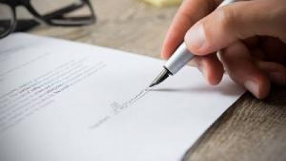 A person signing a document 