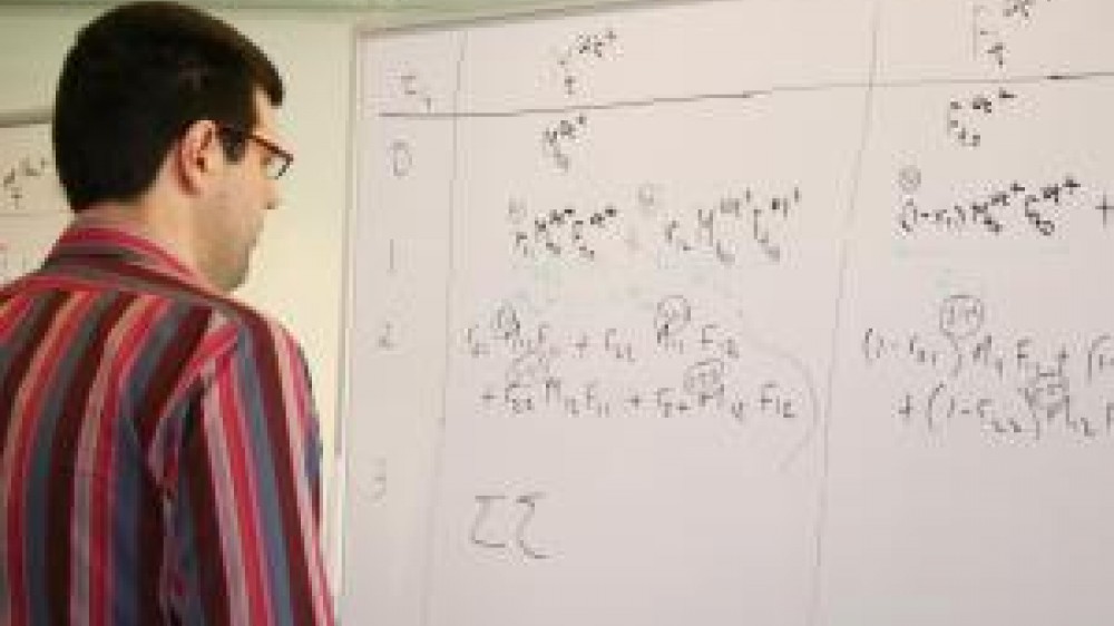 A man looking at mathematical equations on a white board