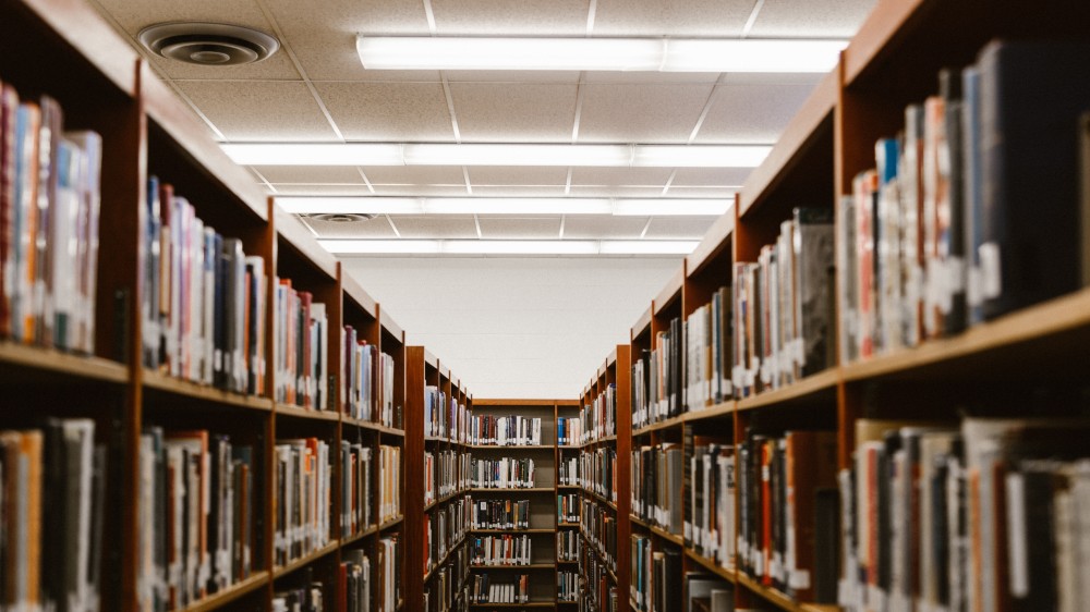 An image of a library with rows of books on shelves visible