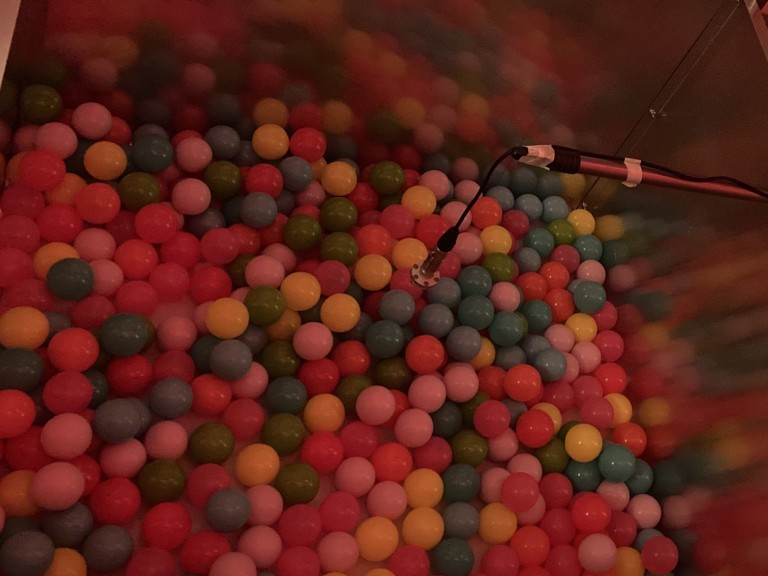 A ball pit for rats with a microphone for recording ultrasonic vocalizations.