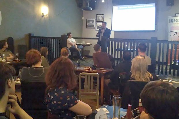 Professor Alastair Sloan on a stage with an audience