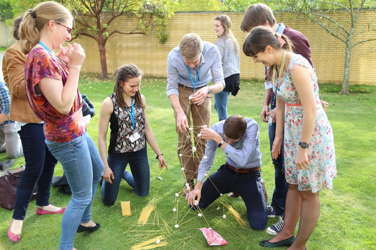 Students on the grass building a marshmallow tower