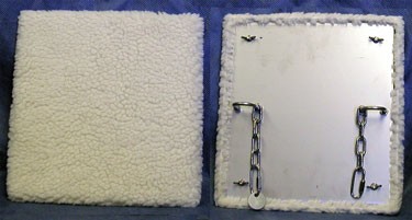White fleece boards, one showing the fleece front, the other showing the fixings for attaching to primate enclosures.