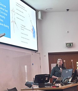 A woman standing in front of a large presentation screen