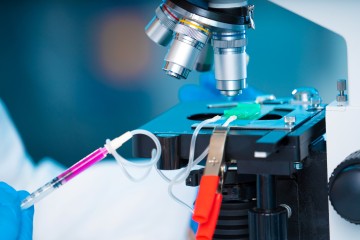 technician with microfluidic device LOC in microbiological lab